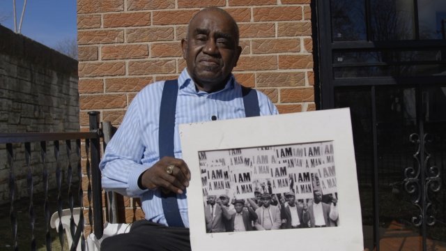 James Riley, a former Memphis sanitation worker and pictured in the center, holds an image from the 1968 sanitation strike.