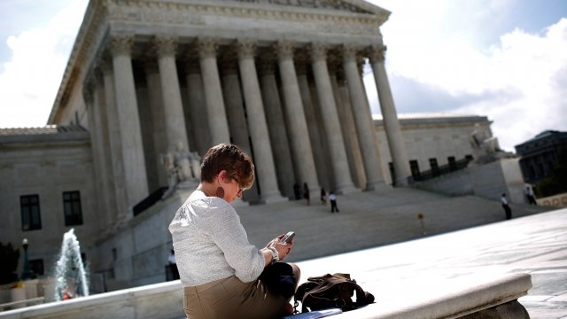 A woman uses her cellphone in front of the U.S. Supreme Court