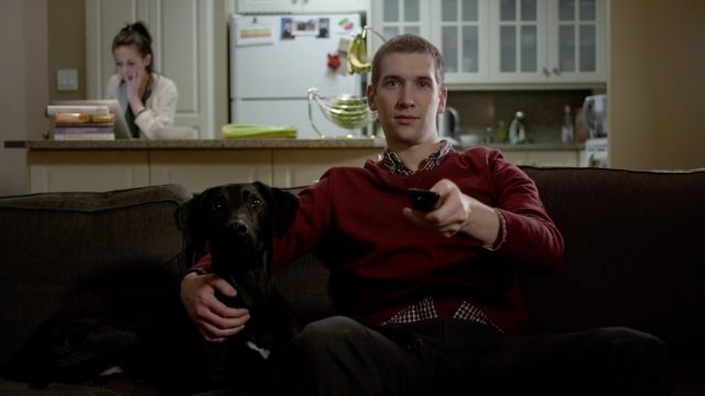Man watches TV with a dog