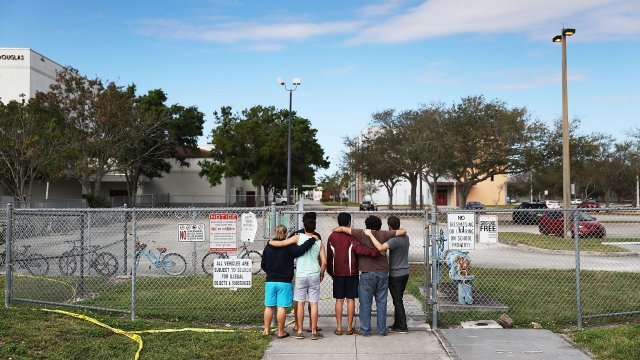 People looking at Marjory Stoneman Douglas High School after its mass shooting