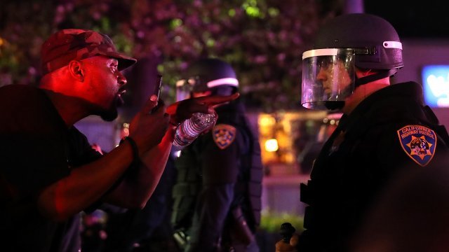 Protester and policeman at rally following the death of Stephon Clark