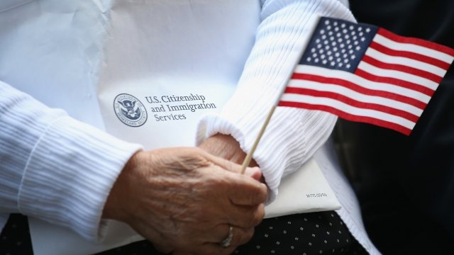 Woman holds U.S. Citizenship and Immigration material