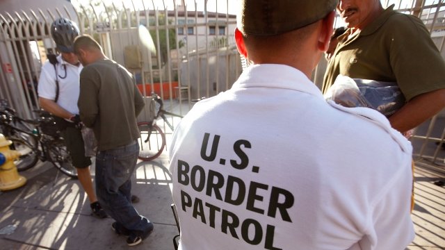 An U.S. Customs and Border Protection bike patrol agent assists Mexican's being returned to Mexico.