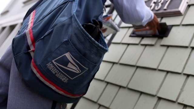 A U.S. Postal Service letter carrier delivers the mail