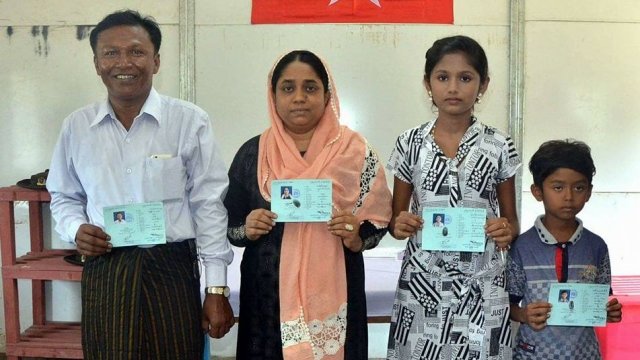 Rohingya family holding ID cards