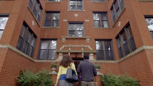 A family walks into an apartment building.