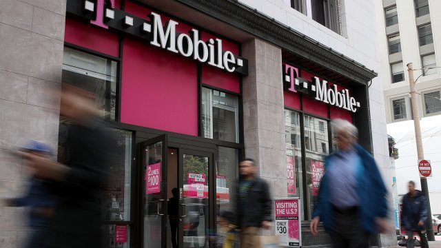Pedestrians walk by a T-Mobile store in San Francisco