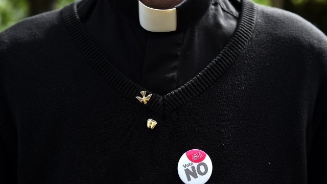 An Irish priest wearing a "vote no" button