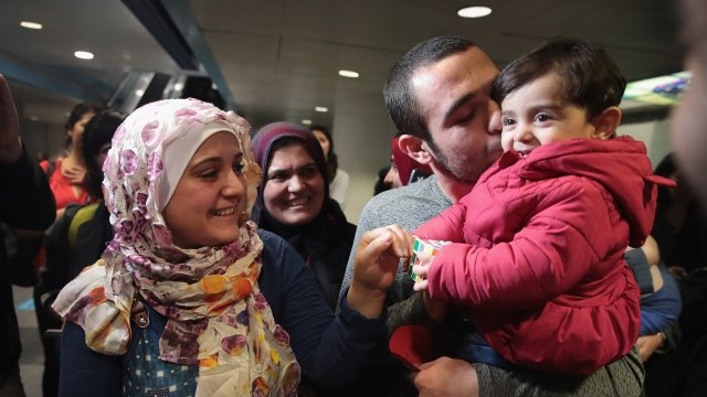 A Syrian refugee and her daughter are greeted by her brother and mother