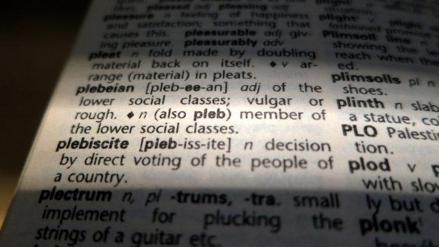 A close up Photo illustration showing a dictionary definition of the word 'plebeian.'