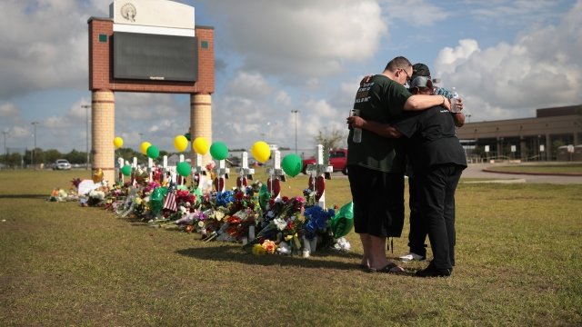 Mourners pray at a memorial in front of Santa Fe High School