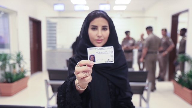 A woman in Saudi Arabia holds up her new driver's license