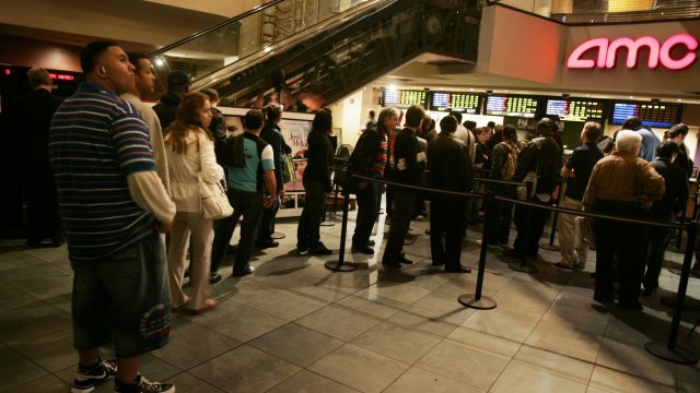 People wait in line at a movie theater