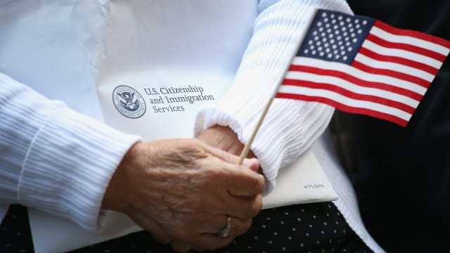 Person holding U.S. Citizenship and Immigration Services packet