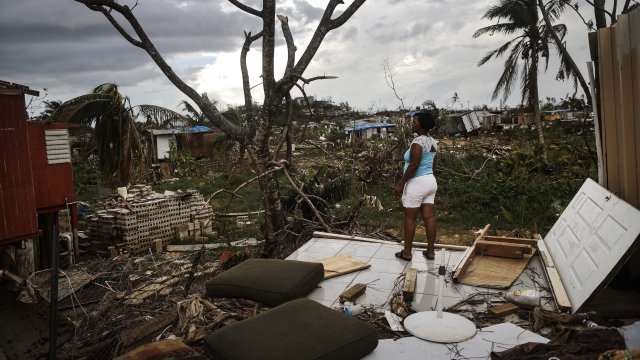 A resident stands on her property about two weeks after Hurricane Maria swept through Puerto Rico.