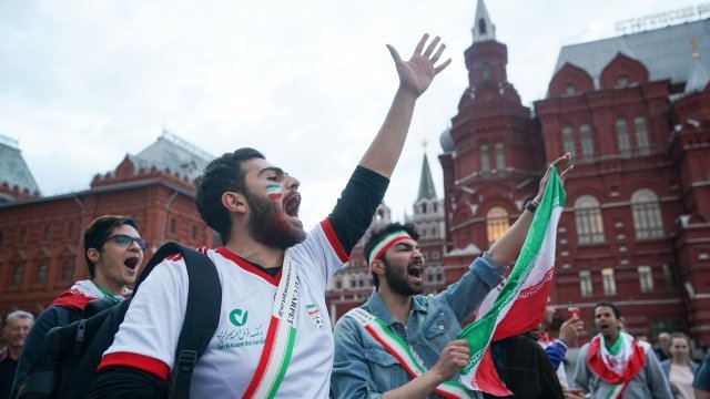 A fan wearing an Iran soccer jersey cheers for his team