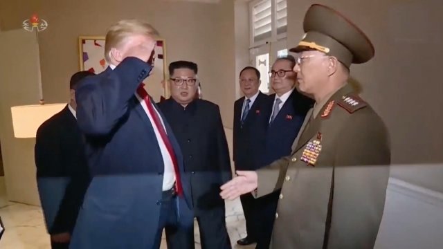 President Donald Trump salutes a North Korean officer
