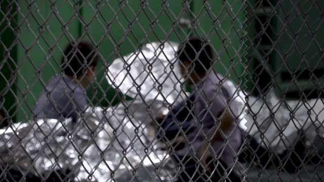 Children wait in an immigration detention facility