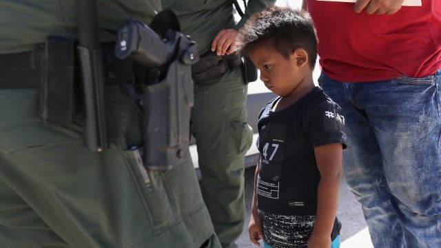 Child standing next to a border patrol officer