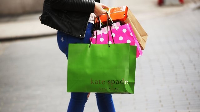 Woman carries a Kate Spade shopping bag