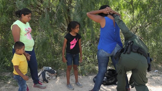 A U.S. border patrol agent searches a migrant family