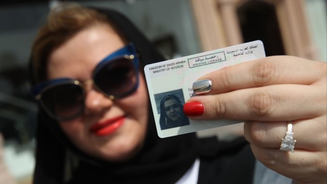 A woman in Saudi Arabia holds up her driver's license