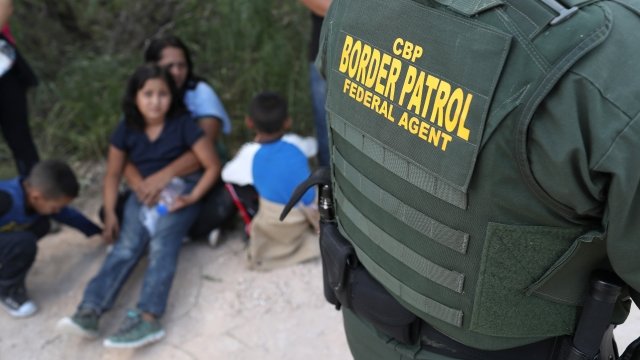 Central American asylum seekers wait as U.S. Border Patrol agents take them into custody in June 2018 near McAllen, Texas.