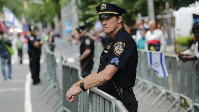 A police officer stands against a barricade.