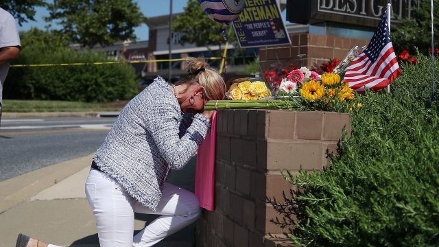 Lynne Griffin pays her respects at a makeshift memorial near the Capital Gazette.