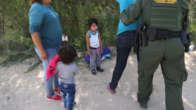 Border patrol agents take migrants into custody