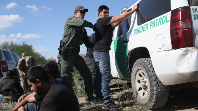 A U.S. Border Patrol officer body searches an undocumented immigrant.