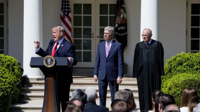 President Donald Trump speaks as U.S. Supreme Court justices Neil Gorsuch and Anthony Kennedy watch
