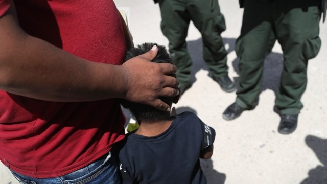 A father and a son speak with agents at the U.S.-Mexico border