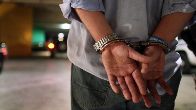 A person stands in handcuffs