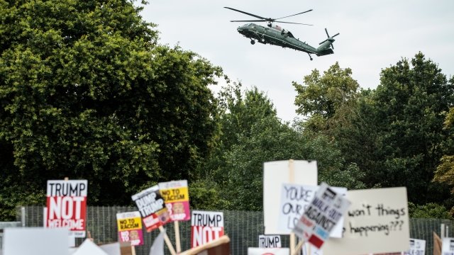 The Marine One helicopter flies overhead as protesters sound off on President Trump