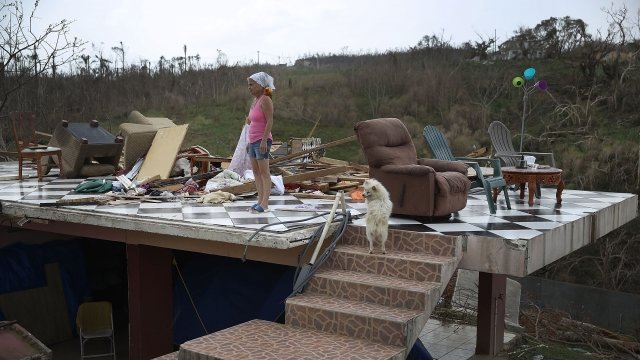 A woman stands in what is left of her home that was destroyed when Hurricane Maria passed through.
