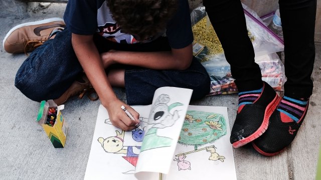 A migrant child colors a picture.