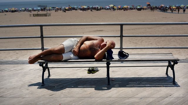 A man rests along the the Coney Island boardwalk on one of the hottest weeks in recent New York City 2013