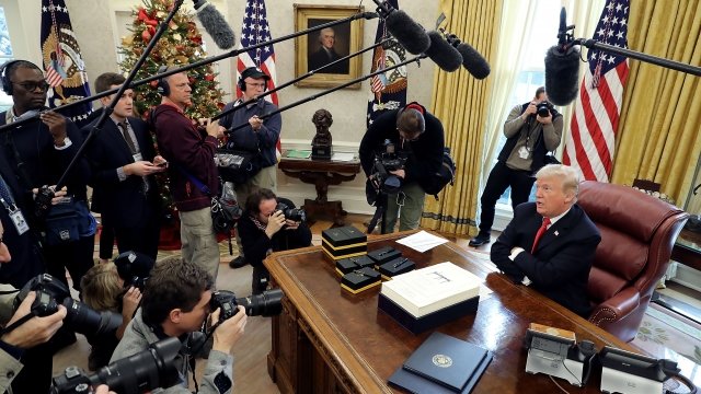 President Donald Trump talks with journalists in Oval Office