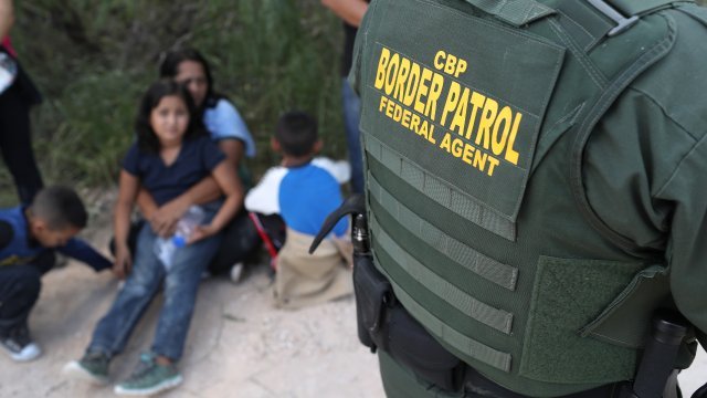Central American asylum seekers wait as U.S. Border Patrol agents take them into custody on June 12, 2018 near McAllen, Texas