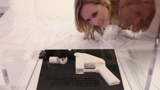 A woman looks at a 3D-printed handgun
