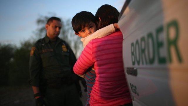 A 1-year-old child from El Salvador clings to his mother.