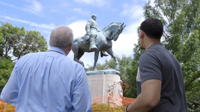 Newsy's Jamal Andress and a Charlottesville resident look at a Confederate monument
