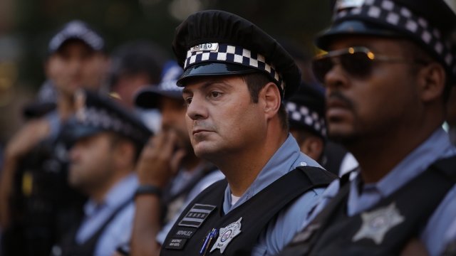 Police officers watch as demonstrators protest the fatal police shooting of Paul O'Neal August 7, 2016 in Chicago, Illinois.