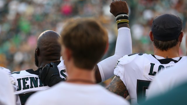NFL players holds up his fist during national anthem.