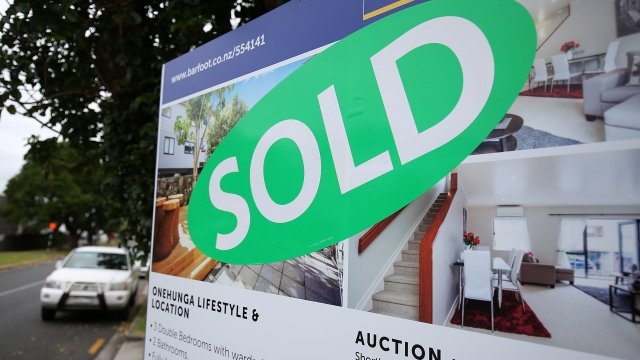 A sold sign sits outside a home in New Zealand.