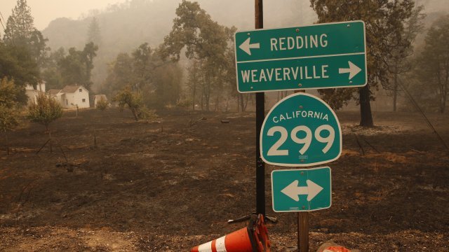 A road sign stands in front of land burned by the Carr Fire