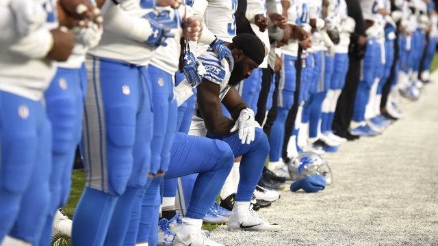 Detroit Lions players kneel during the national anthem