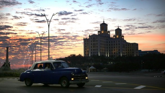 A picture of a vintage car in the foreground, with the Hotel Nacional in the background.