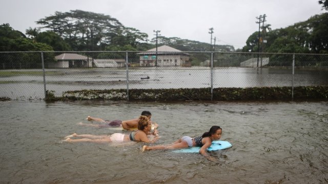 Residents bodyboard in floodwaters after Tropical Storm Lane